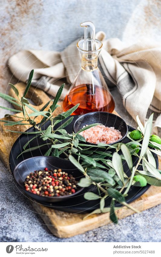Spices and olive tree branches background bottle bowl cook food green leaves himalayan salt spices ingredient kitchen oil pepper pepper mix pink salt spicy