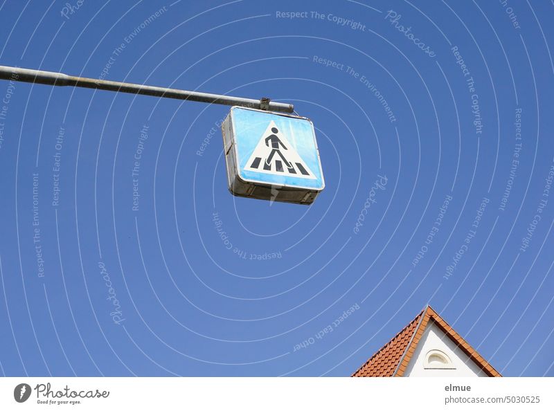Top of a roof gable with a traffic sign - crosswalk - attached to a metal pole above it against blue sky Road sign VZ 350-20 Gable Tiled roof