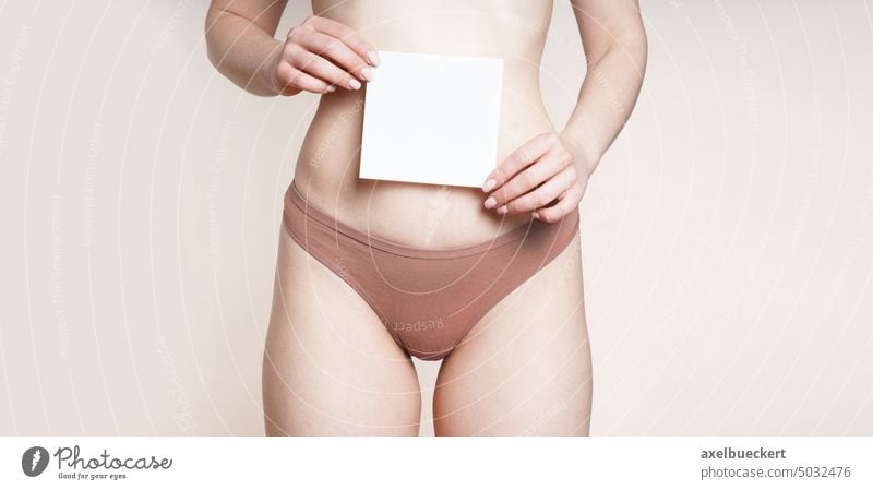 A woman with lowered red panties is sitting on the toilet, showing a clean  tampon. Close-up. The concept of menstruation and gynecological problems  Stock Photo