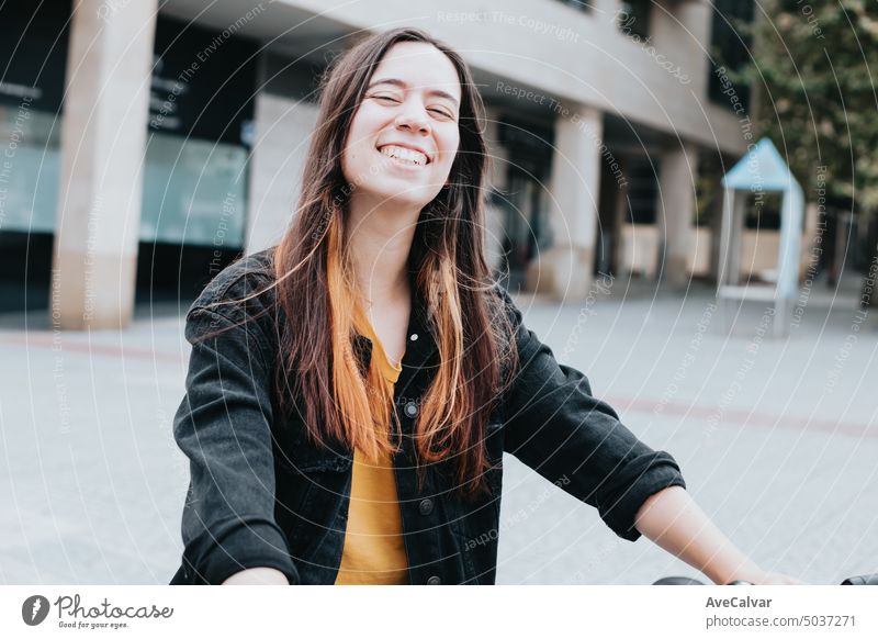 Woman pointing an electric bike, rental service on the city, new sustainable transport ways, young people advertising. young adult person bicycle using phone