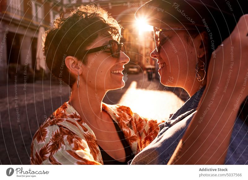 Glad couple hugging against sunset light on street women smile girlfriend together happy love madrid spain female young sunlight twilight sunglasses evening