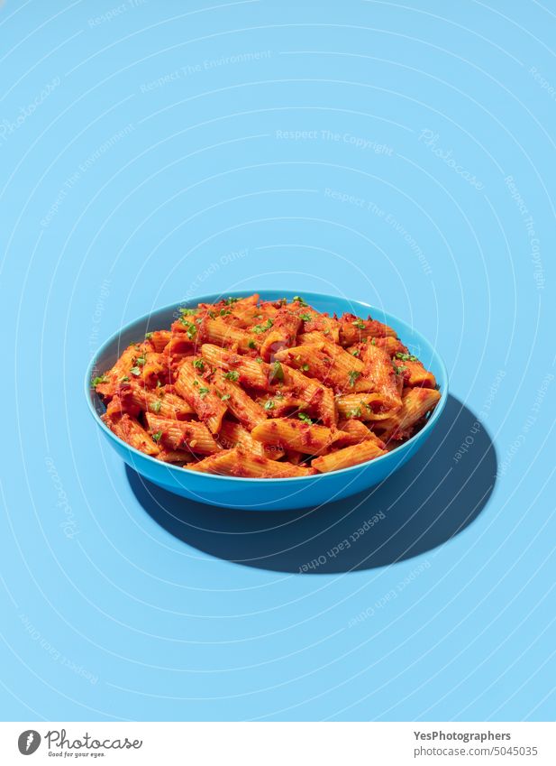 Penne pasta bowl isolated on a blue background above arrabbiata bright carbs chili classic color cooked copy space creative cuisine cut out delicious dinner