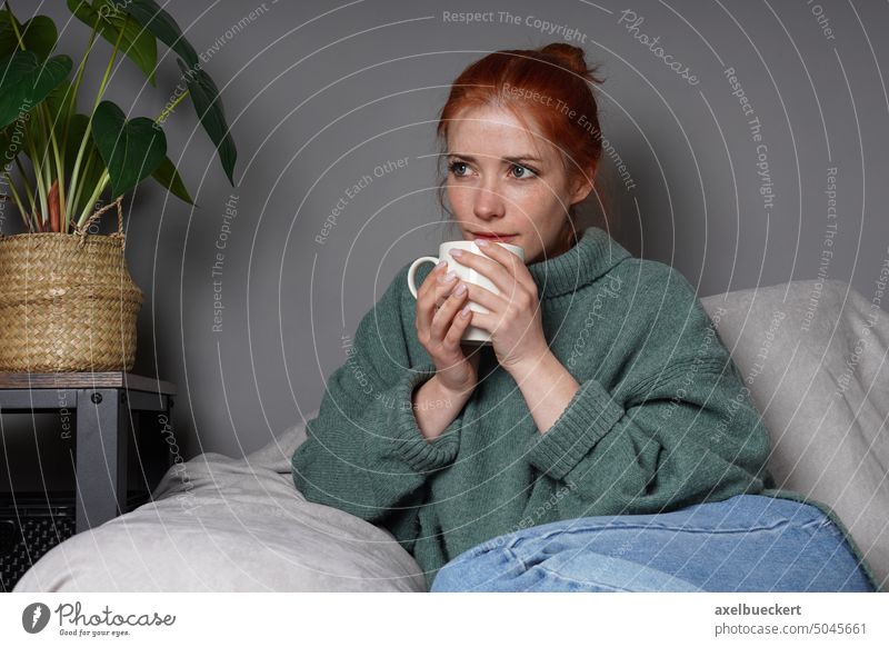 woman relaxing at home drinking coffee cup daydreaming thinking armchair real people pensive sitting indoor lady person young adult girl casual mid adult