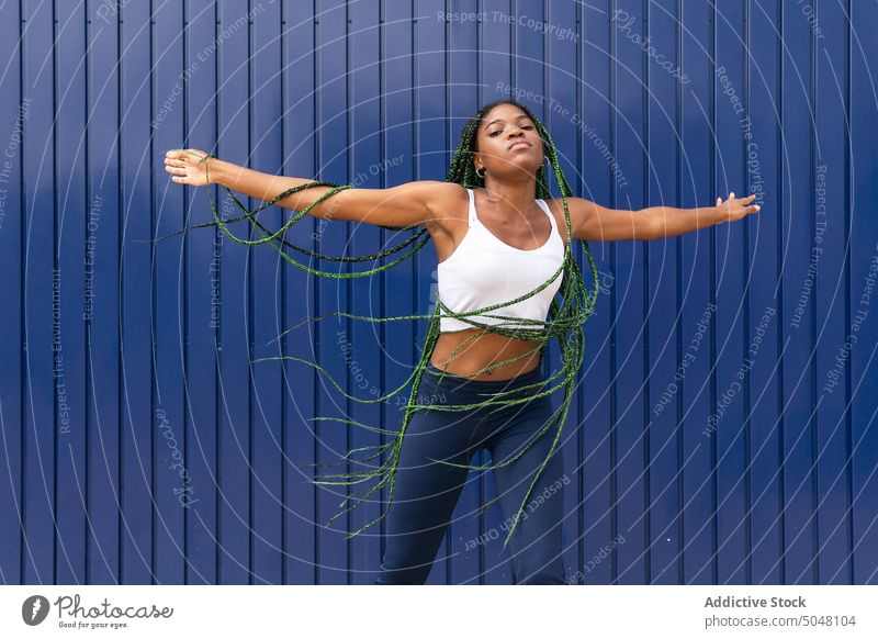 Young dynamic black woman dancing on street - a Royalty Free Stock