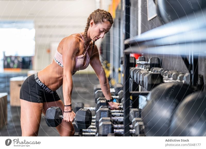 Fotografia do Stock: Fit strong woman lifting weights. Working out with  dumbbells