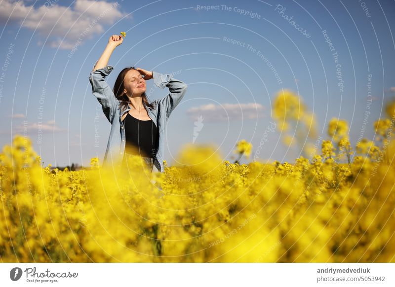 young beautiful woman in a field with yellow blooming rapeseed. girl in yellow floral field, rapeseed plantation, summer vacation concept beauty nature female