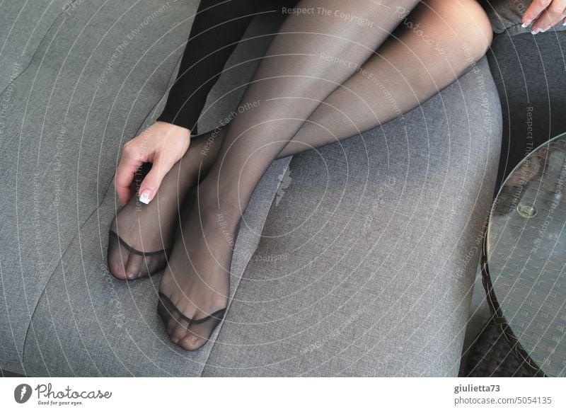 Foto de Young woman in underwear is painting her toenails do Stock