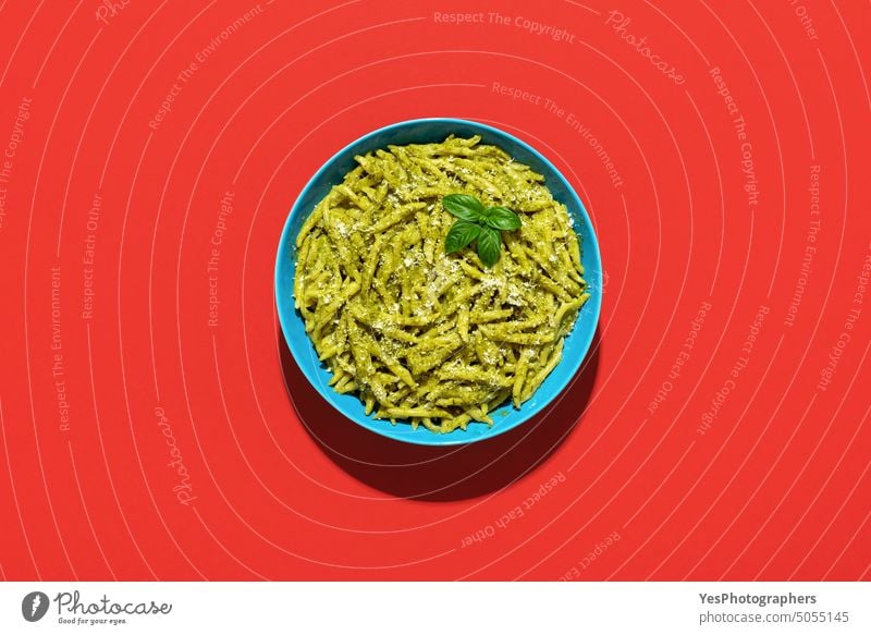 Pasta with pesto sauce, top view on a red background above basil bowl bright carbs cheese classic color copy space creative cuisine cut out delicious dinner