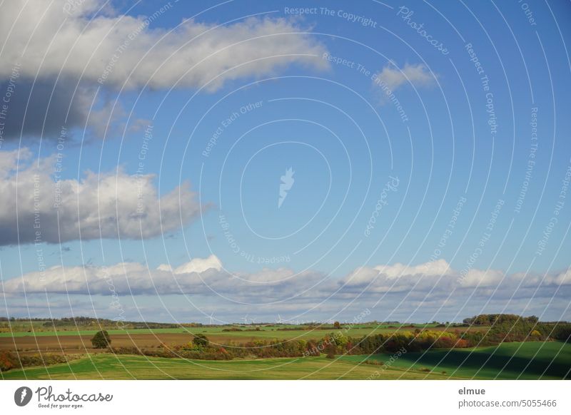 Foothills location with autumn fields and trees, blue sky with fair weather clouds and a wind farm on the horizon foothills windmills Autumn far vision Sky blue