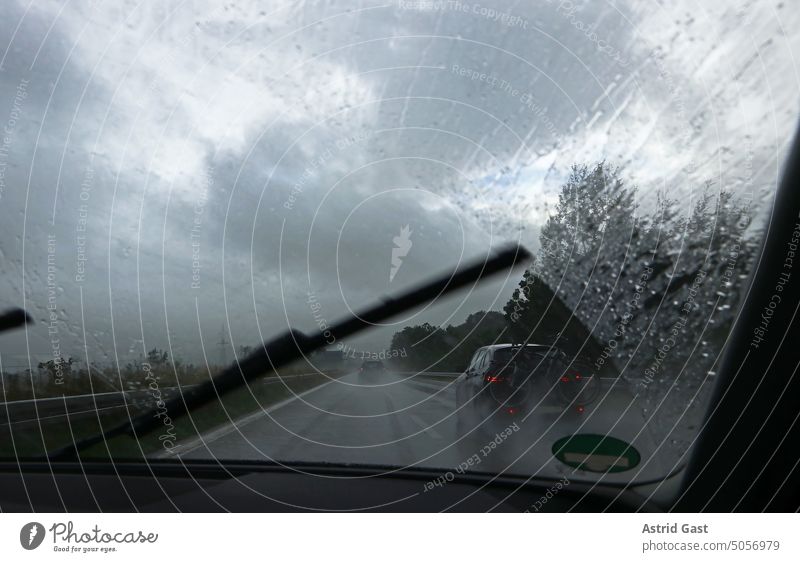 A windshield wiper in heavy rain on the highway car Driving Rain Highway Windscreen wiper Slice Car window Transport peril Dangerous Risk Risk of accident Wet