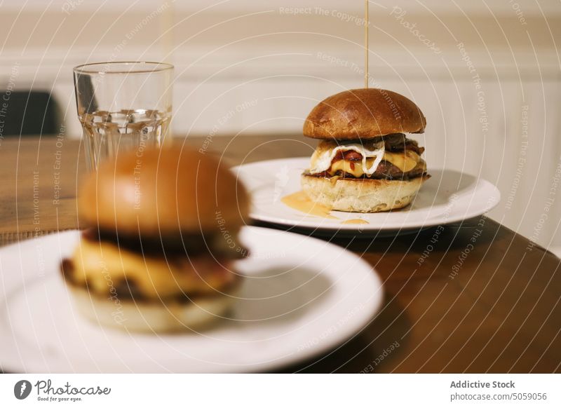 Delicious fresh made burger on plate hamburger delicious scrumptious toothpick egg bun food fast food serve table tasty meal dish yummy appetizing lunch eat