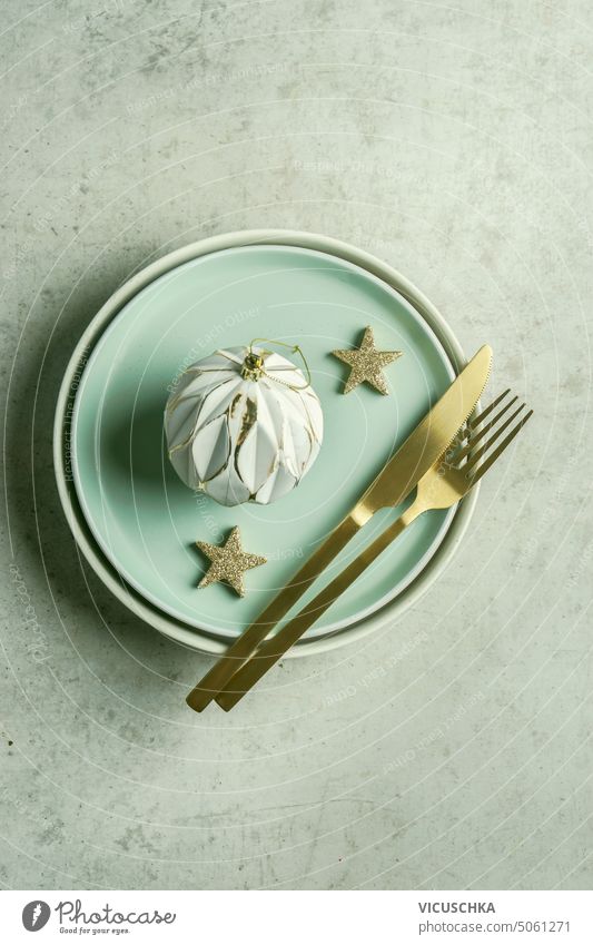 Christmas table setting with plate and golden cutlery , stars and vintage bauble. Top view christmas top view festive new year copy space decoration