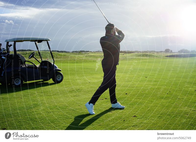 Golfer hitting the fairway in the sunshine Golf course Green Sports Golf club Playing Leisure and hobbies Grass Exterior shot Lawn Tee off Concentrate Day