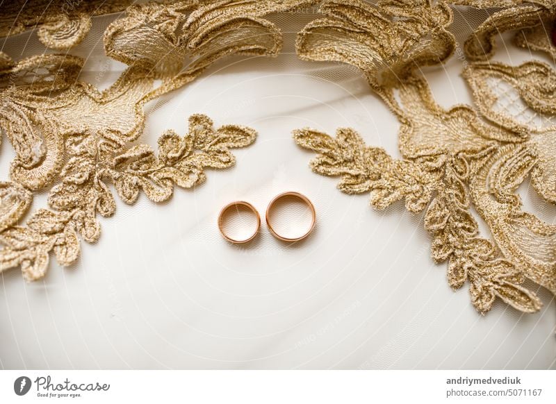 Pair of golden wedding rings over veil with lace. wedding accessories. selective focus love marriage romance white celebration symbol romantic pair bride two