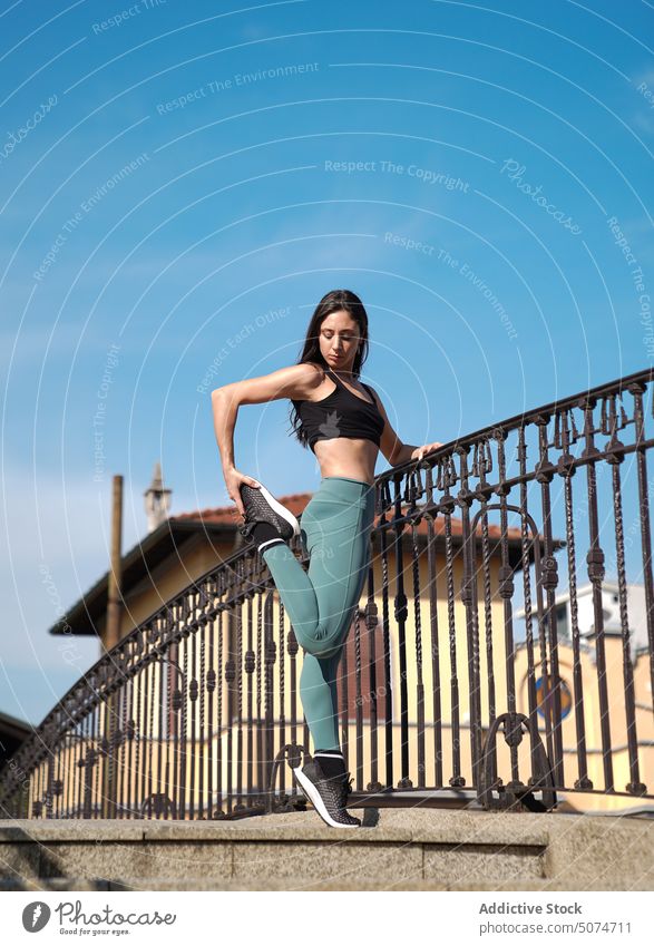 Full-length slim fit female in white sports attire. Woman standing on white  stairs relaxing during training Stock Photo - Alamy