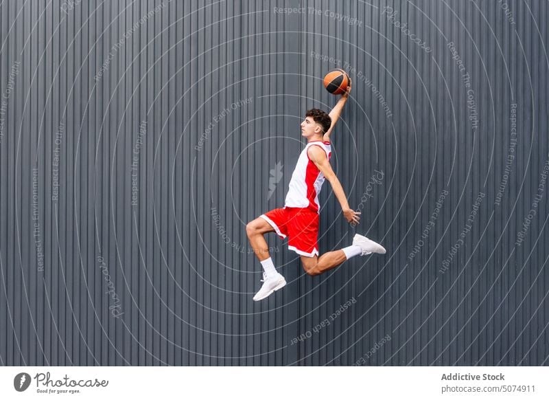 Male basketball player with ball against dark background portrait sportsman jump leap streetball hold sports ground goal game acrobatics male hobby practice