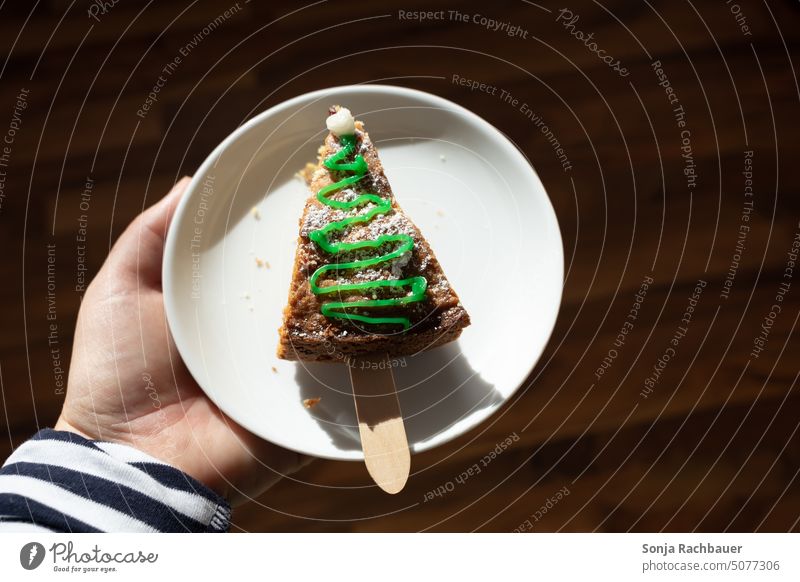 One hand holds a plate with a piece of cake. Christmas. Cake Plate Christmas & Advent Baking cute Food Icing Ornate Feasts & Celebrations Public Holiday Dessert