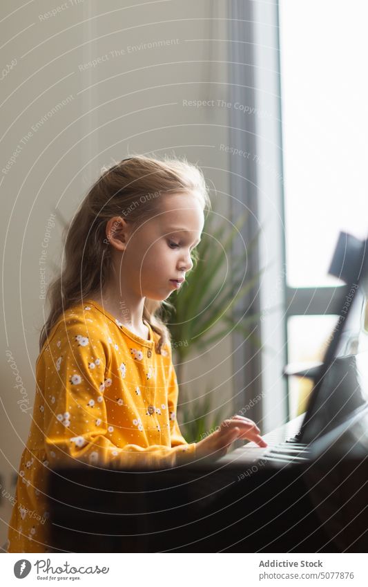 Little blond girl practicing music with the piano child learning person musician pianist childhood education practice instrument classical indoor play hobby