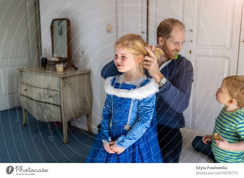 Father combing his daughter's hair modern manhood genderblend real life real people bonding family indoors quality time house parenting kids enjoyment together