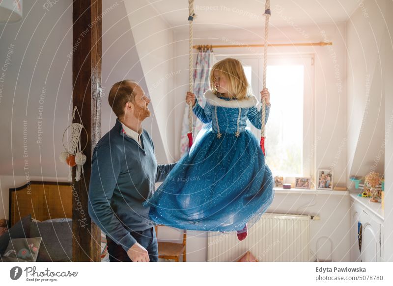 Father playing with his daughter at home modern manhood genderblend real life real people bonding family indoors quality time house parenting kids enjoyment