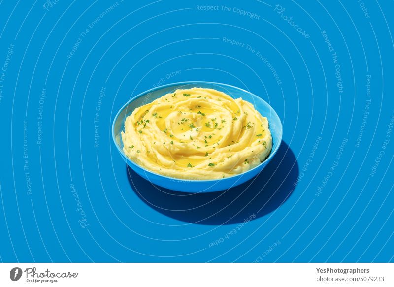 Mashed potatoes bowl minimalist on a blue background above bright butter color cooked copy space cream creamy cuisine cut out delicious dinner dish food fresh