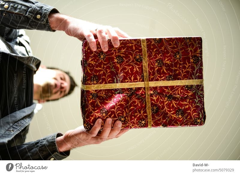 Man holding a gift in his hands - giving and receiving gifts Christmas Gift make a present to Donate Anticipation stop Christmas gift Surprise Giving of gifts