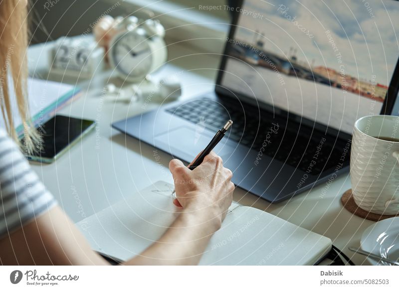 Woman sitting at table by the window and using laptop work home woman creative freelancer working comfort looking desk browsing lifestyle business occupation
