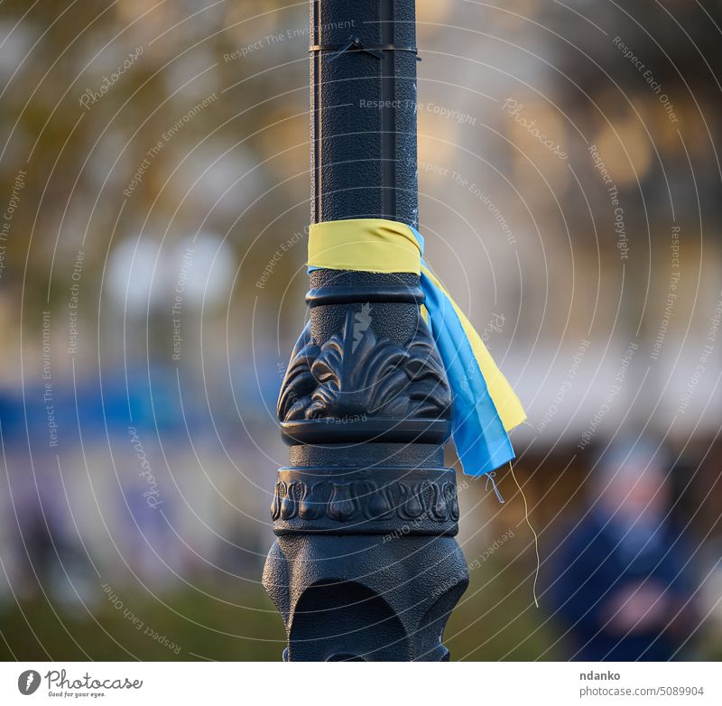 Blue and yellow silk ribbon tied on a metal tube. Ukrainian flag symbol, struggle for independence kherson street blue fabric freedom celebration concept