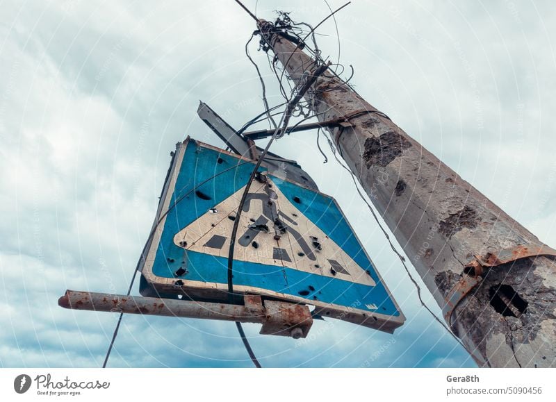 concrete pillar broken by shards and a road sign against a gloomy sky Kherson Kyiv Lugansk Mariupol Russia Ukraine Zaporozhye abandon abandoned attack blown up