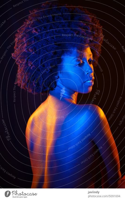 Naked black woman under neon light sensual nude illuminate tender topless colorful dark model female african american ethnic curly hair afro slim feminine