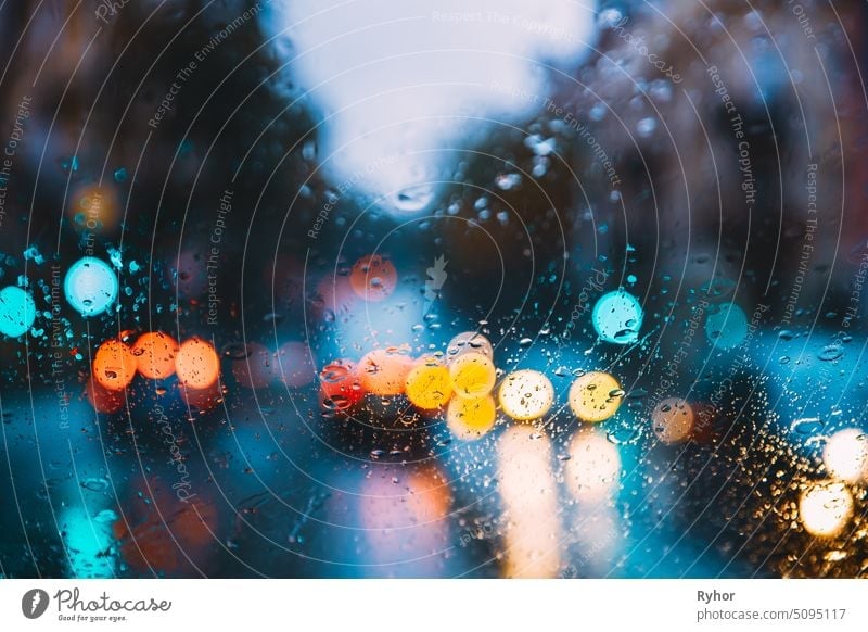 Rain Water Drops On Blue Glass Background In Night Or Evening Street Lights. Street Bokeh Boke Lights Out Of Focus. Autumn Street Abstract Backdrop vivid