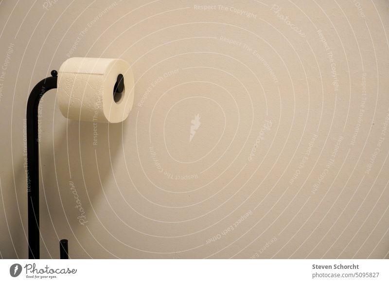 Toilet paper on black stand in front of white wall Bathroom Paper Coil Clean Deserted toilet paper Personal hygiene Interior shot Living or residing toilet roll