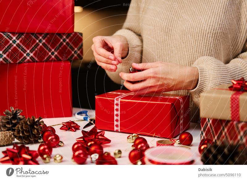 Female hand hold a box wrapped in red paper and tied with a red silk ribbon,  holiday Stock Photo by ndanko