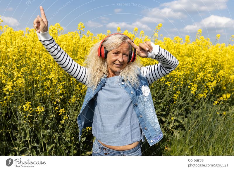Elderly Woman lenjoy the music with headphones outside aged beauty retired casual pretty looking background audio european favorite music summer earphones mp3