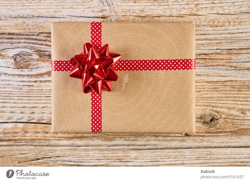 Festive gift box on wooden background. Present for holiday christmas present birthday festive ribbon wrapping celebration party bow red beautiful celebrate