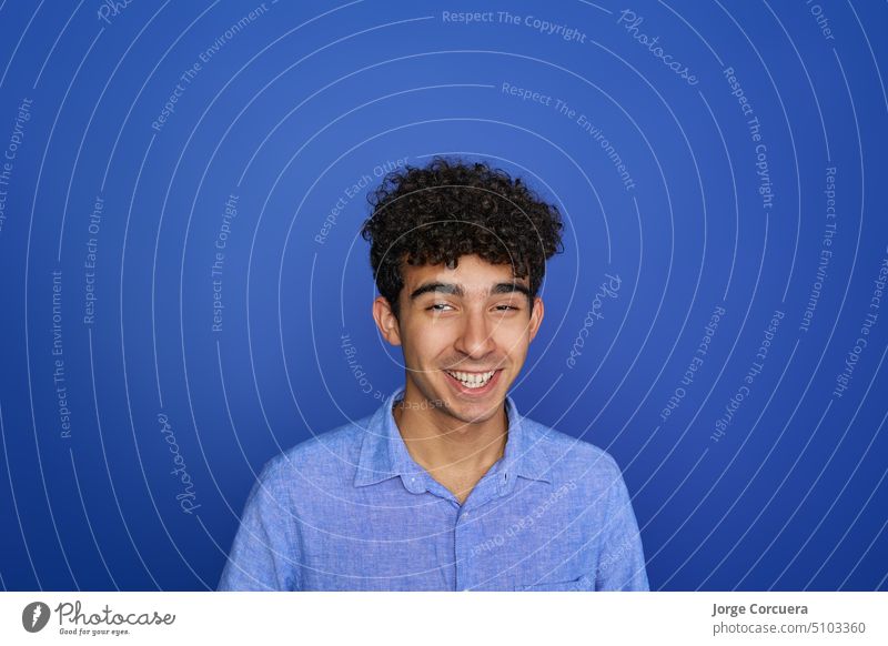 Portrait of a handsome young brunette serious teen on a blue background. future worker casual gentleman portrait young worker significant studio isolated
