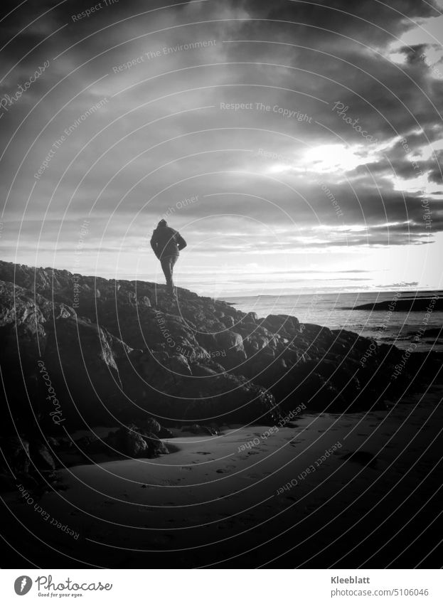From the land darkness moves to the sea - a person climbs the rocks - black and white shot black-and-white Exterior shot one person Rock Beach Ocean Water