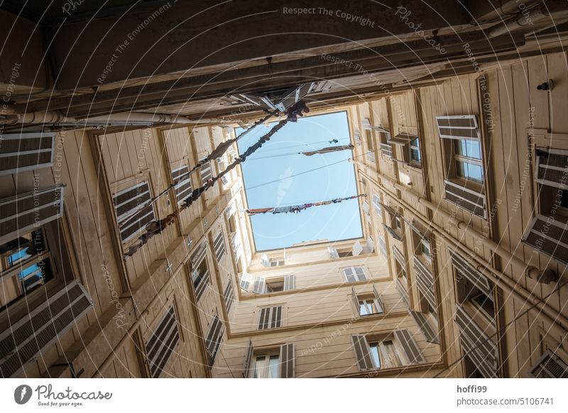 View from a courtyard upwards on clotheslines in front of Mediterranean blue sky Interior courtyard Upward Laundry Old town Backyard Downtown Worm's-eye view