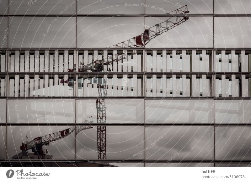 Cranes on a construction site reflected in a glass facade of a modern architecture Construction site Architecture Facade Pane mirror Glas facade urban