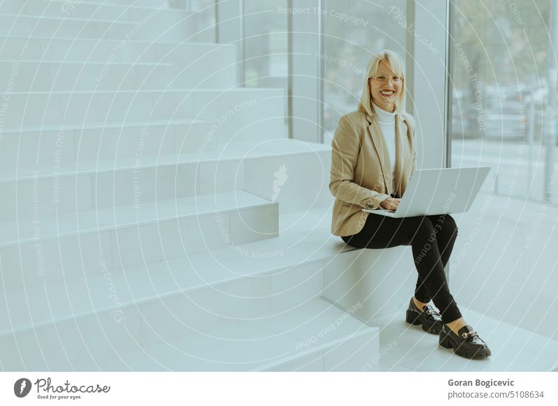 Business woman with laptop on modern office stairs more adult Eyeglasses Blonde Business person Businesspeople Businessman Businesswoman Caucasian Communication