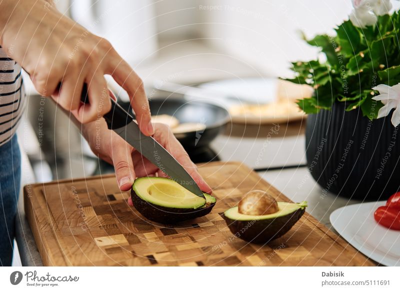 Woman cutting avocado on cutting board to prepare breakfast organic food toast ingredient cooking kitchen chopping green slices woman nutrition slicing fresh