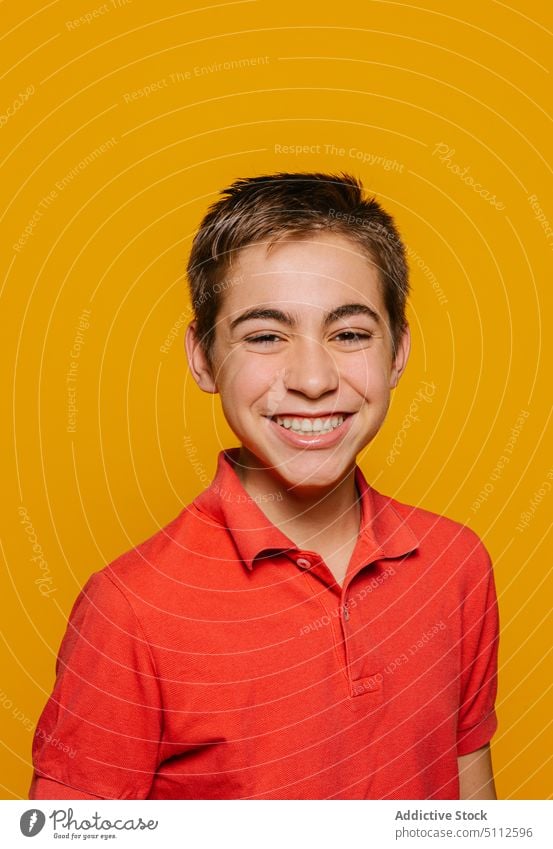 Cheerful boy smiling and looking at camera on yellow background happy cheerful smile joy bright positive glad vivid optimist vibrant style casual colorful