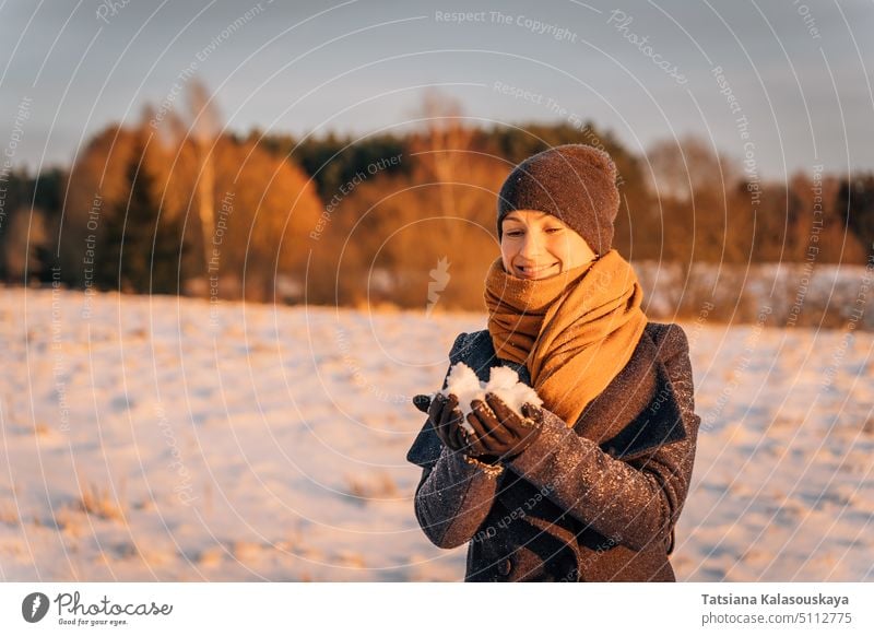 Young woman n warm clothes enjoying in snow - a Royalty Free Stock