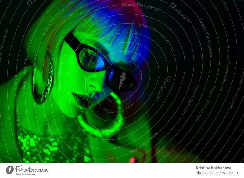Portrait of glamorous woman under neon green light. Nightclub, trendy outfit. Teenager, zoomer Z-generation. Copy space african dancing young stylish night