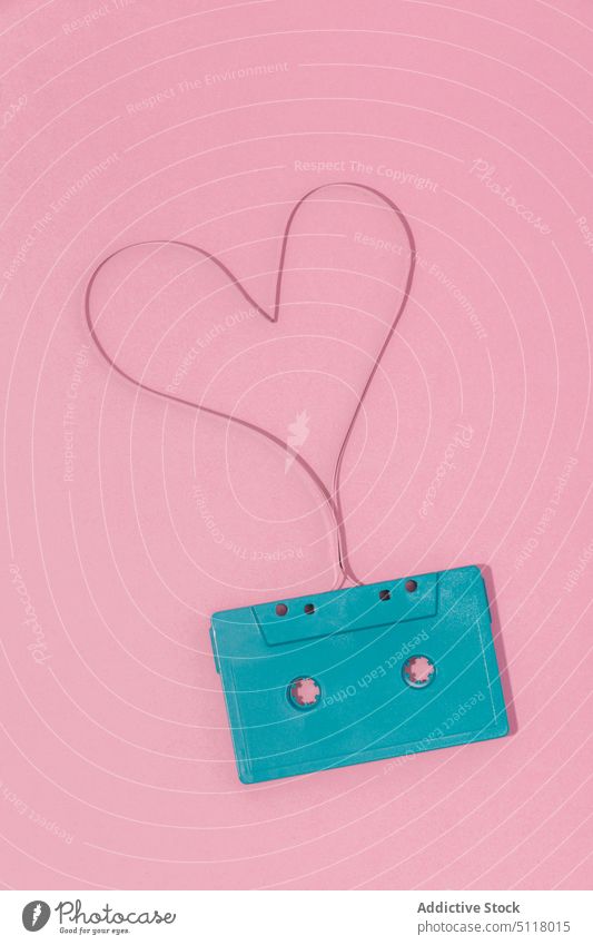 Retro cassette with heart shaped tape on pink surface retro music audio symbol nostalgia record analog 90s plastic stereo song love object minimal romantic
