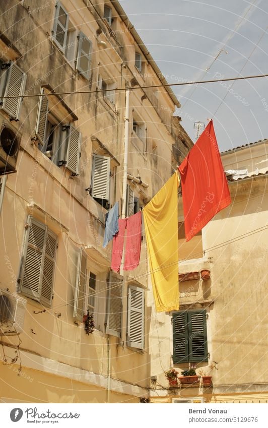 Laundry in the south clothesline Washing Dry Hang Greece Summer vacation Southern Mediterranean sea Facade Old Simple Sunlight Shadow Warmth variegated Yellow