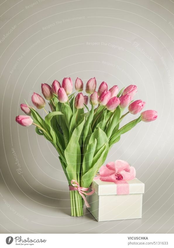 Lovely tulips flowers bunch on table with gift box, front view lovely womens day mothers day valentine celebration natural beauty romantic background pink
