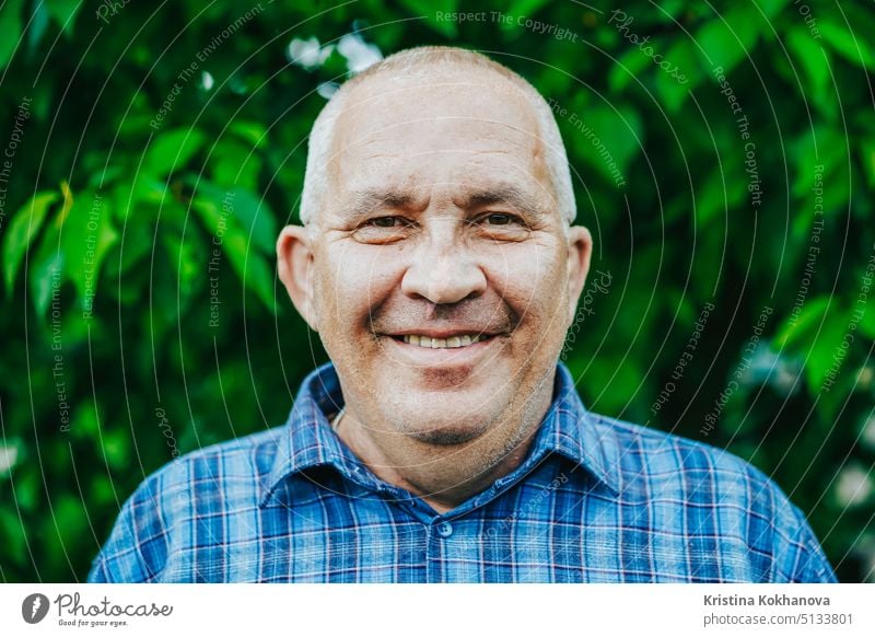 Portrait of cheerful smiling aged man in park. Caucasian grandfather looking at camera and smiling person portrait adult male lifestyle retirement senior