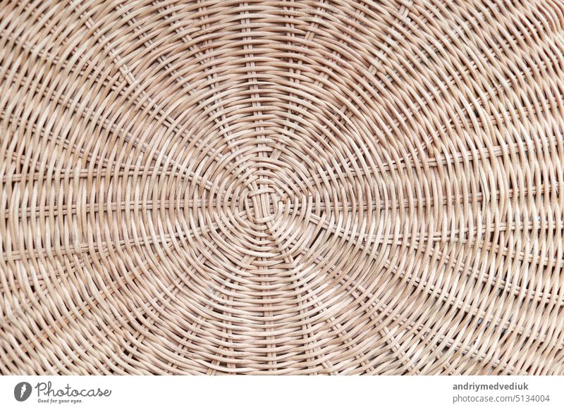 Circular weave rattan pattern, round rattan furniture background light brown texture, weave rattan texture and background. a fragment of a basket made of willow twigs or garden furniture, texture.