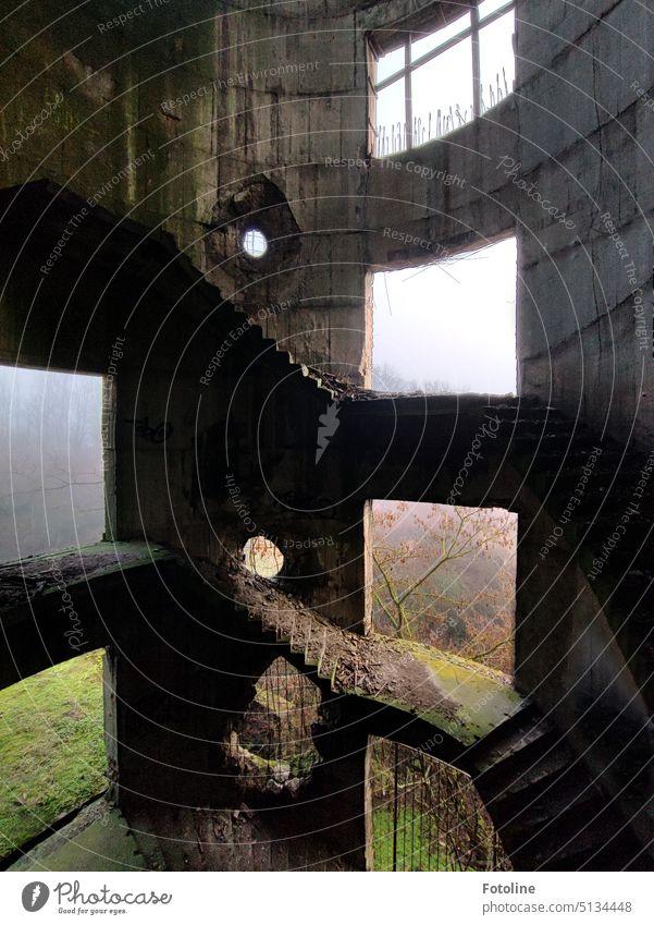 In the old chimney of the power plant, the stairs lead far up. In the old masonry are large holes through which you can see the landscape outside shrouded in mist.